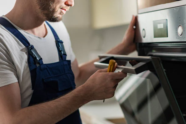 Technician testing the controls of a built-in oven
